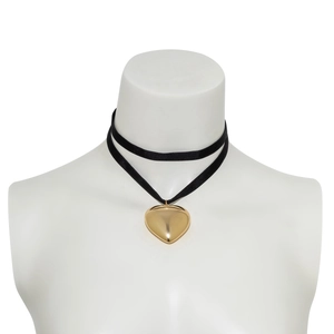 Detail of a large gold heart pendant on a black velvet ribbon necklace for women
