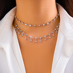 Chaîne de corps argentée à double couche avec pendentifs en strass sur une chemise blanche