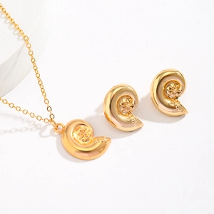 Detailed view of golden spiral snail shell jewelry set with star patterns