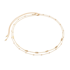 Detail of gold double-layer body chain featuring infinity charms and polished beads