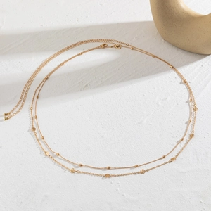 Detail of double-layer gold chain with smiley face pendants and lobster clasp