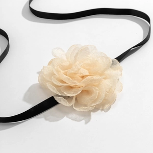 Detail of elegant champagne organza flower choker with a slim black satin ribbon tie
