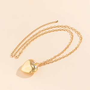 Gepolijste gouden hartvormige hanger aan een schakelketting met karabijnsluiting