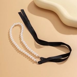 Detail van elegante dubbele parelketting met luxe zwarte satijnen strikbanden
