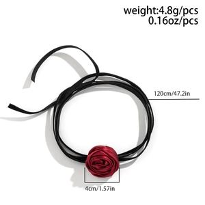 Detailed close-up of a red satin rose choker with long black ribbon ties on white back