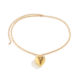 Detail van dubbellaagse gouden metalen tailleketting met een gepolijste 3D hart hanger