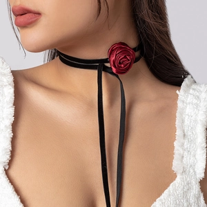Detail view of the deep red satin rose and long black ribbons on the choker necklace