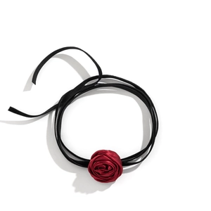 Detail of red fabric rose flower and black satin ribbon on vintage style choker necklace
