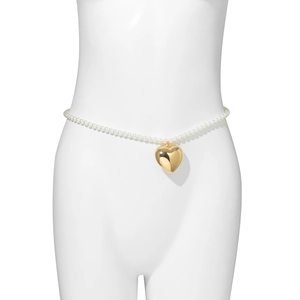 Detail van een witte parel buikketting met een grote gepolijste gouden hartvormige hanger