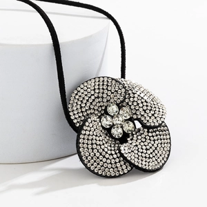 Detailopname van een bloemen choker ketting met glanzende strass op zwarte blaadjes
