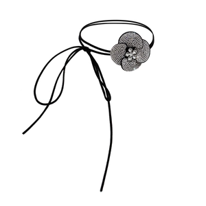 Macro-opname van camelia-choker met fonkelende strassteentjes op zwart waxkoord