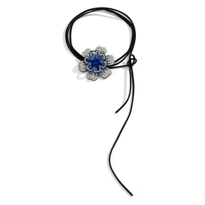 Detailweergave van de gelaagde blauwe strass bloemhanger met zwarte koordkwastjes