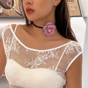 Detail van roze kristallen camelia bloem choker aan een zwart koord op model