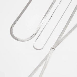 Macro detail of silver snake chains in various widths with polished herringbone texture