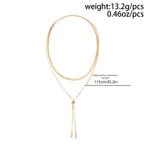 Detail showing gold snake chain necklace with adjustable 115cm slider and metal bead charm