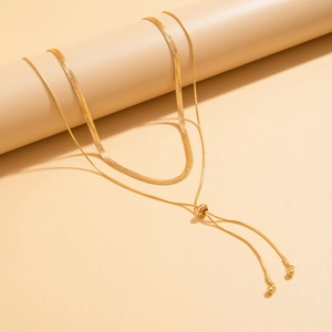 Close-up of golden layered snake bone chain necklace with adjustable sliding bead detail