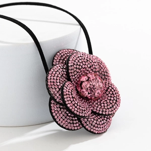 Macro-opname van de gelaagde roze bloemenchoker met fonkelende steentjes op zwart koord