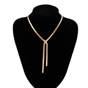 Detail of elegant gold snake bone Y-necklace displayed on a black velvet neck bust