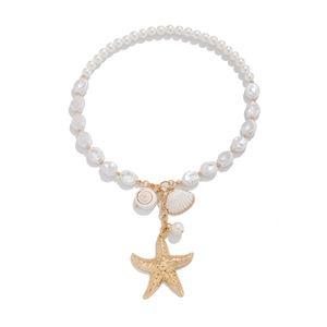Detail view of beach pearl necklace with gold starfish and shell pendants on white background