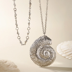Macro shot of silver ammonite shell pendant with nautical textured chain necklace