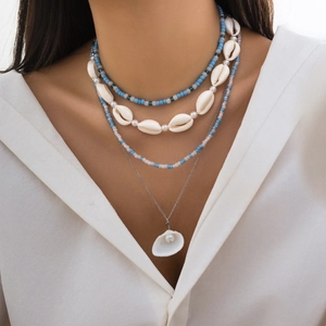 Macro detail of multilayer bohemian beach necklace with sea shells and beads on model