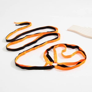 Detail of orange and black elastic leg chain with metal ring and crisscross straps