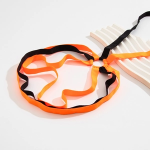 Detailed macro view of black and orange elastic leg chains with heart-shaped metal rings