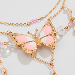 Detail einer goldenen Schmetterlingskette mit rosa Emaille, Perlen und feinen Perlen