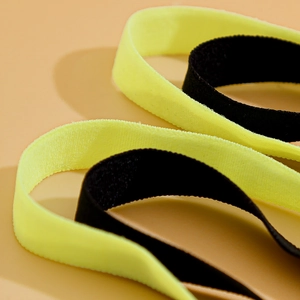 Detail of cross elastic leg chain with fluorescent yellow and black textured fabric
