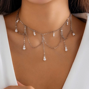 Κοντινό πλάνο γοτθικού choker με ασημένιες φούντες και κομψά λευκά μαργαριτάρια