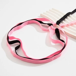 Detail of pink and black elastic leg chain with crisscross straps and heart accents