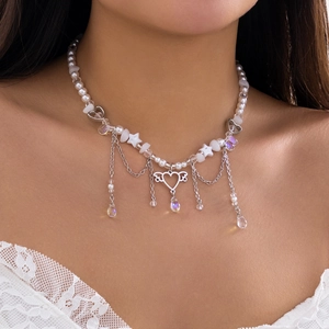 Nahaufnahme der Perlen-Choker-Halskette mit Herz-Flügel-Anhänger und feinen Kettenquasten