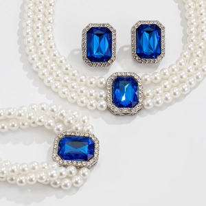 Dettaglio del set di perle multistrato con gemma blu rettangolare e cristalli lucenti