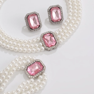 Dettaglio di un set di gioielli 3 pezzi con gemme rosa sfaccettate e perle sintetiche