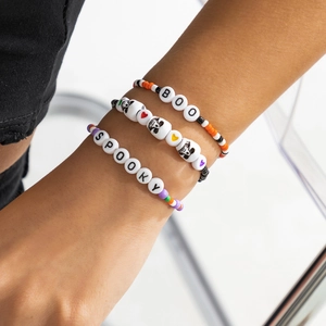 Macro dei braccialetti di Halloween con perline, scritte BOO e SPOOKY e piccoli teschi
