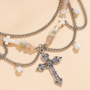 Detail einer mehrlagigen Perlenkette mit Vintage Silberkreuz und rosa Perlen
