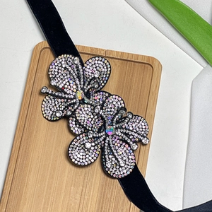 Close-up of black velvet choker with rhinestone flowers and iridescent crystals