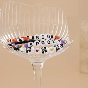 Dettaglio del set di braccialetti di Halloween con testi BOO e SPOOKY in un bicchiere