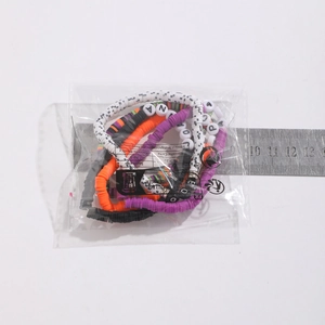 Dettaglio di braccialetti elastici colorati con perline di lettere in busta di plastica