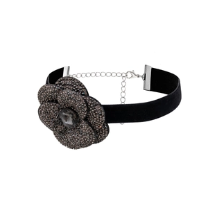 Close-up of black velvet choker featuring a crystal floral pendant with adjustable silver chain
