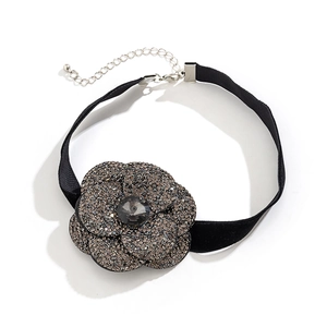 Detail of black velvet choker featuring a crystal-encrusted flower with a grey center stone