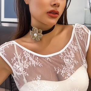 Detailed close-up of a black velvet choker with a pearl and crystal flower centerpiece