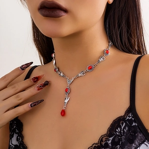 Close-up of Gothic red gemstone necklace with bat portrait and water drop tassel detail