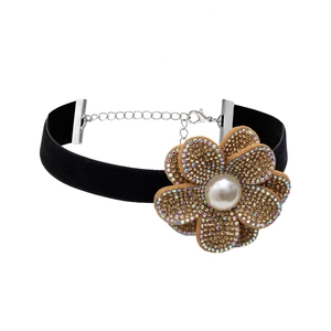 Detailed macro view of a black velvet choker featuring a rhinestone flower and a pearl bead