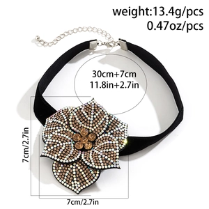 Detailed view of black velvet choker with large rhinestone floral pendant and sizing specs
