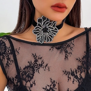 Elegant black velvet choker with rhinestone flower pendant on a female model
