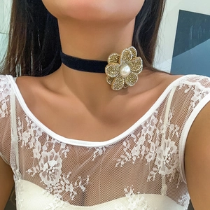 Elegant black velvet choker with a gold crystal floral pendant and a white center pearl