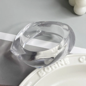Macro detail of clear resin ring featuring an asymmetrical twisted geometry design