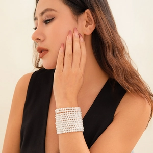 Primer plano de la pulsera de perlas multicapa con un elegante diseño apilado en la muñeca