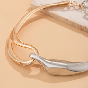 Dettaglio macro della collana girocollo bicolore oro e argento con linee organiche
